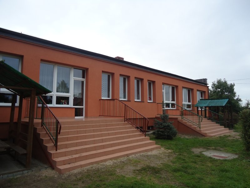 Tył budynku przedszkola: docieplona elewacja w kolorze ceglastym, nowa stolarka okienno-drzwiowa