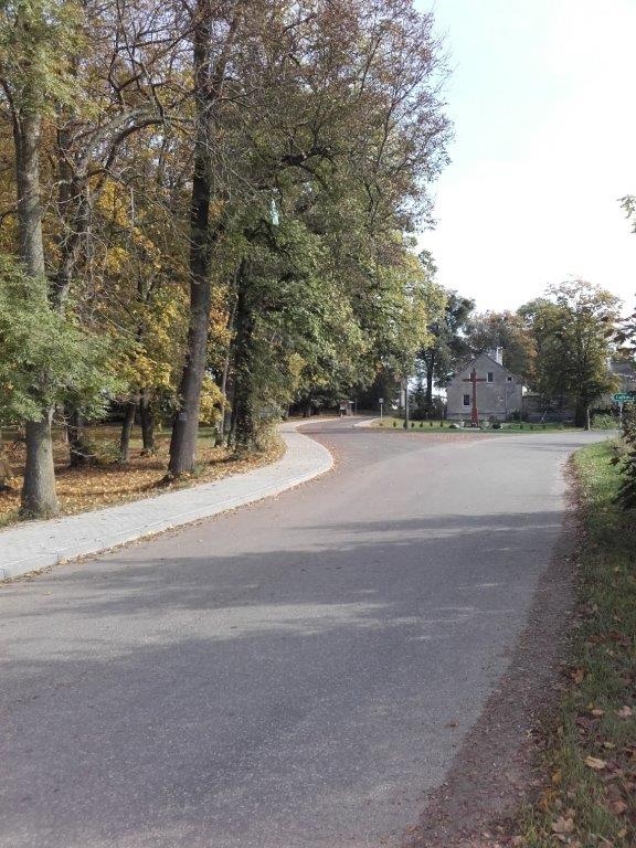 Droga przez Frącę, skrzyżowanie z drogą na Lalkowy. Po lewej park i nowy ciąg chodnika z kostki brukowej